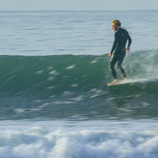 Donnie Hedden surfing a custom longboard surfboard shaped by shaper Shea Somma at Rincon, Santa Barbara, California